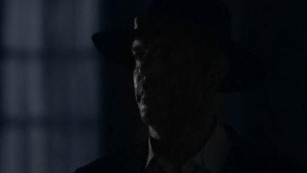 El hombre del sombrero aparece en la oscuridad
