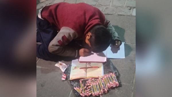 Niño hace tareas en la calle mientras vende dulces en Bolivia
