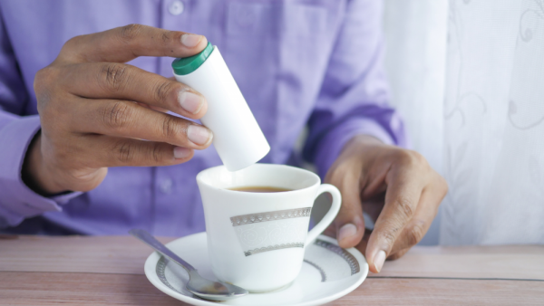 <p>Persona endulzando un té.</p>Expertos aclaran anuncio de la OMS sobre edulcorantes y piden más datos en envases

