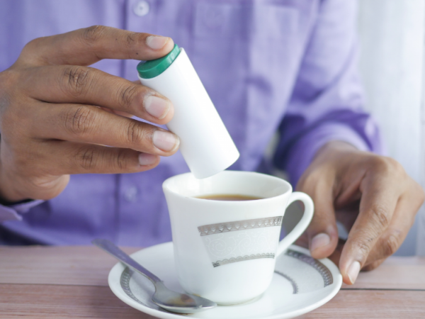 Persona endulzando un té.