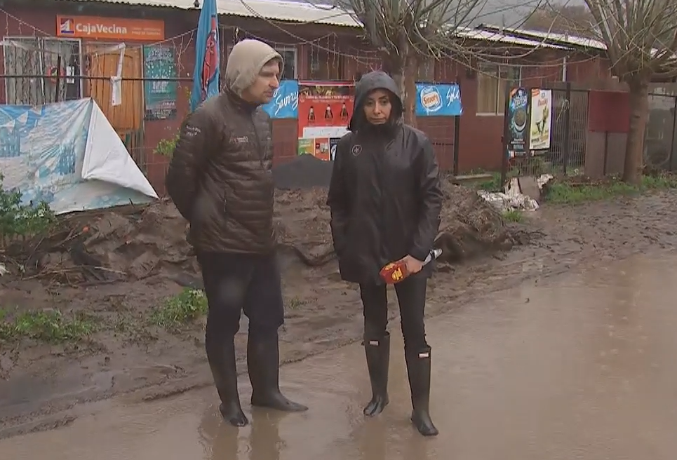 Carmen Gloria Arroyo y Askaan Wohlt en Coltauco. Con los pies hundidos en el agua producto de la inundación.