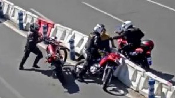 La imagen del día: hombre prende fuego a su moto y muerde a Carabinero
