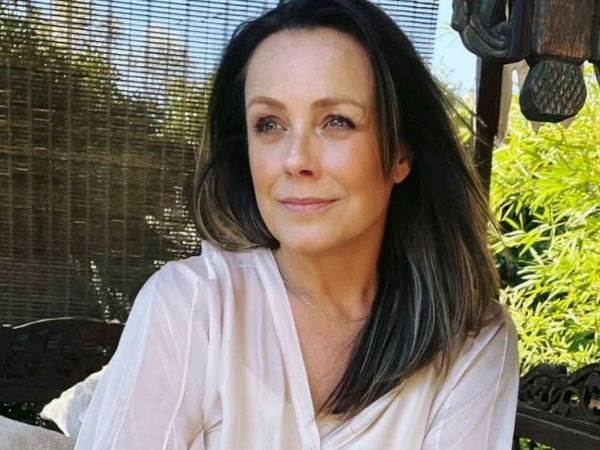 Claudia Conserva sobre un sillón acompañada de abundante vegetación.