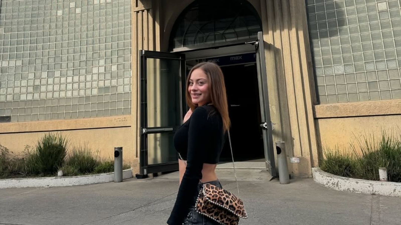 Skarleth Labra con polera negra y un bolso animal print.