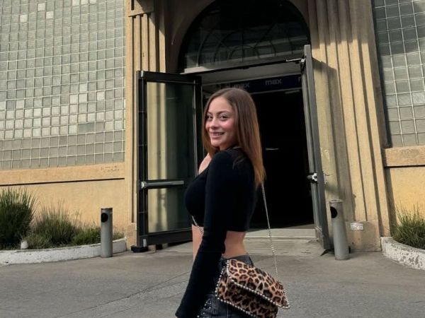 Skarleth Labra con polera negra y un bolso animal print.