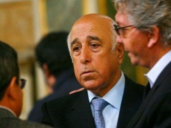 Nelson Acosta vistiendo un terno negro, camisa celeste y corbata plateada.