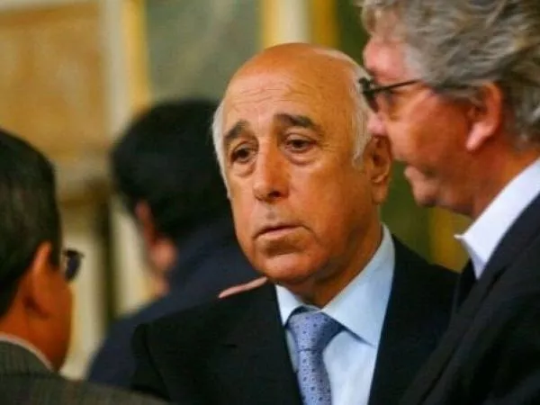 Nelson Acosta vistiendo un terno negro, camisa celeste y corbata plateada.
